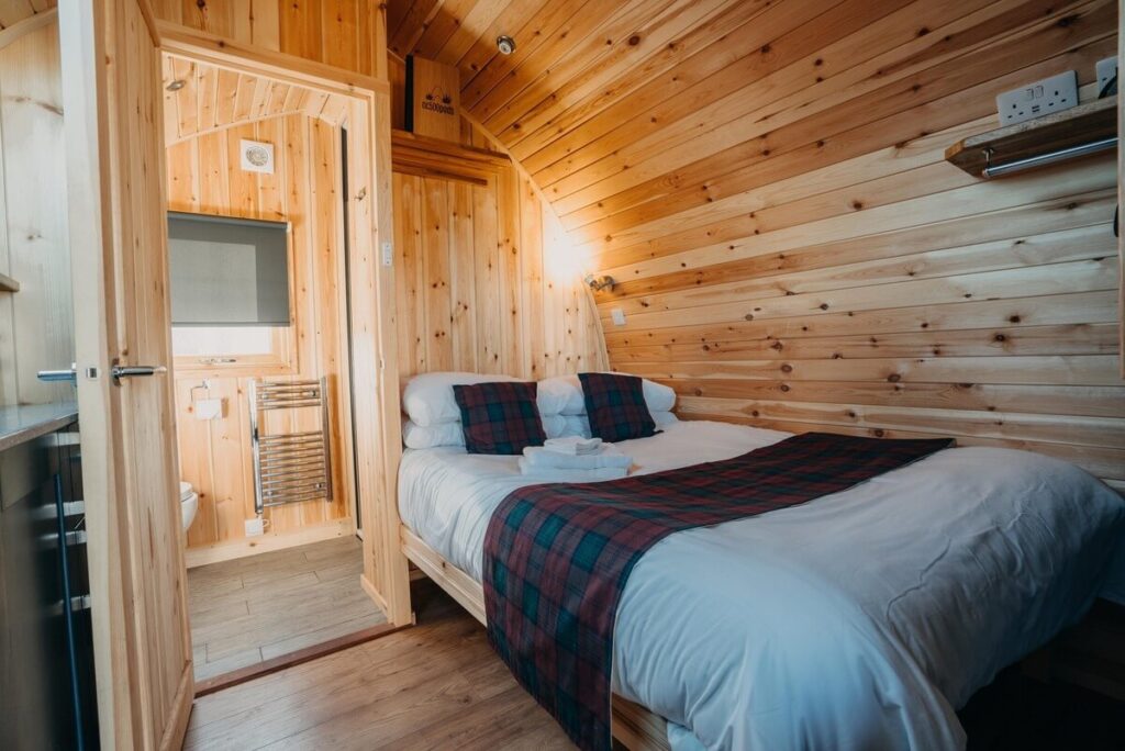 Interior of a modern glamping pod at Achmelvich on the North Coast 500, featuring a double bed and cozy furnishings
