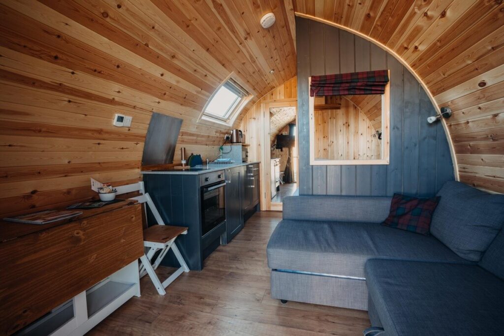L-shaped sofa inside a glamping pod at Achmelvich, North Coast 500 – converts into a bed for family-friendly stays
