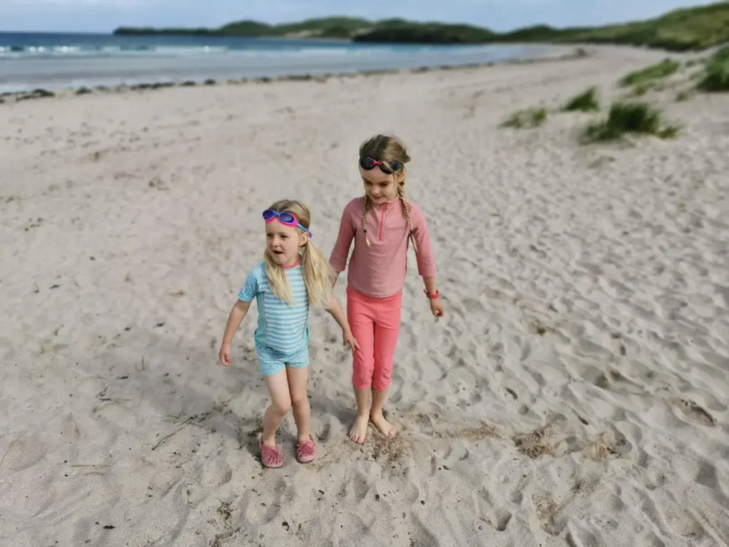 A wide, sandy beach with rolling dunes and turquoise waters near Durness, Scotland.