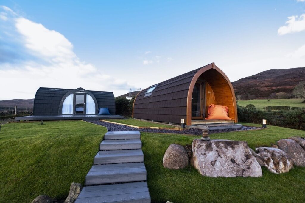 A scenic view of glamping pods in Brora along the North Coast 500, surrounded by greenery and a peaceful setting.