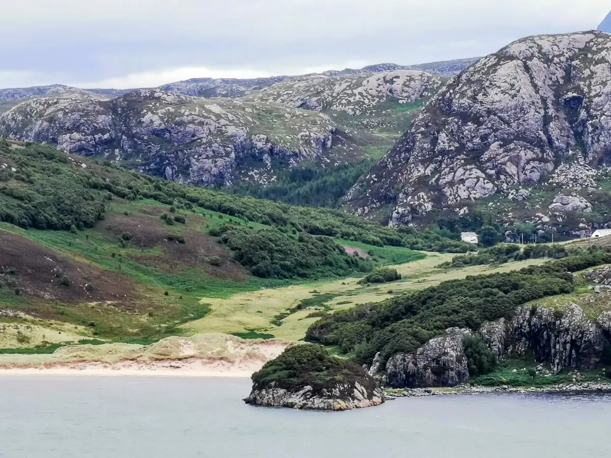 Scenic coastal road along the North Coast 500, surrounded by cliffs and open water.