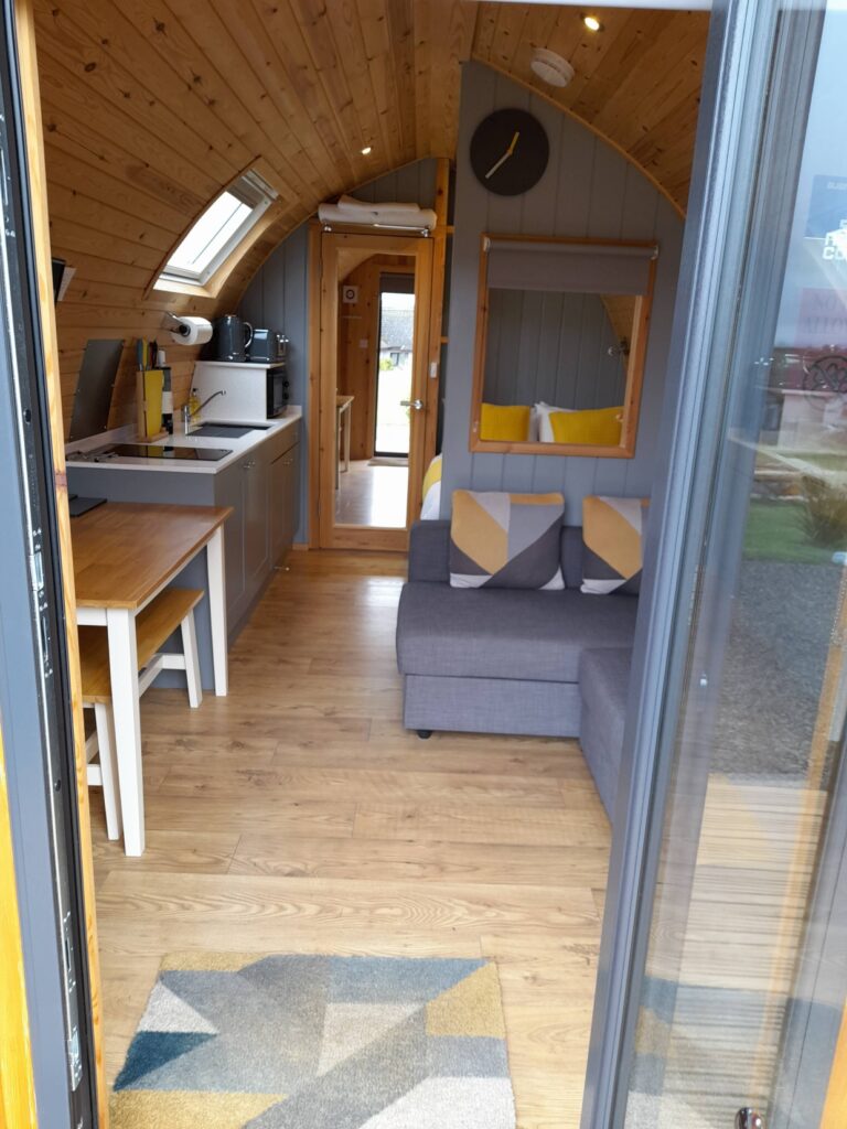 Interior view of a North Star Glamping pod, showcasing comfortable furnishings and a warm, inviting atmosphere along the North Coast 500 route.