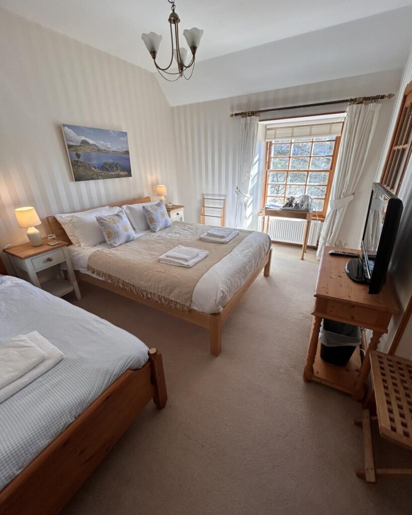 Exterior view of Scourie Lodge and Gardens, showcasing its historic charm and lush surroundings along the North Coast 500 route.