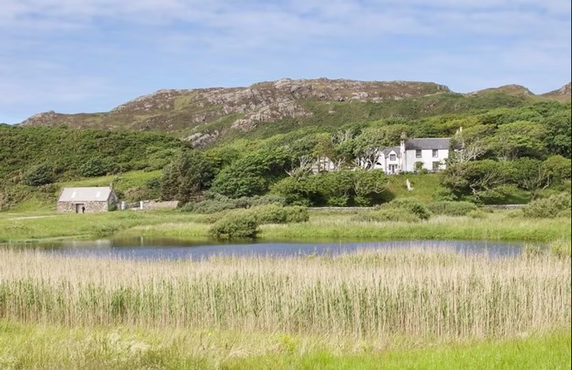 Scenic view of Scourie Lodge and Gardens, a tranquil bed and breakfast nestled along the North Coast 500, surrounded by lush greenery.