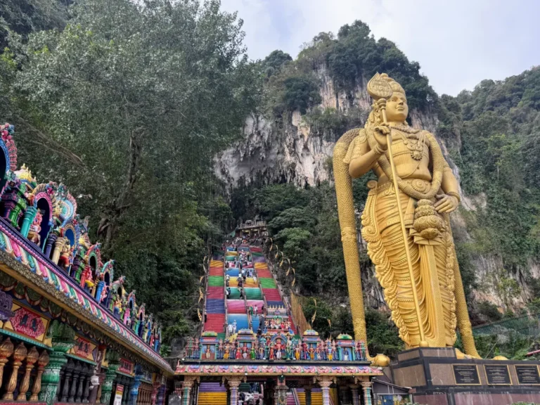 2 Week Malaysia Itinerary - Golden statue of Lord Murugan and rainbow staircase at Batu Caves, a must-see cultural site on our Malaysia itinerary.