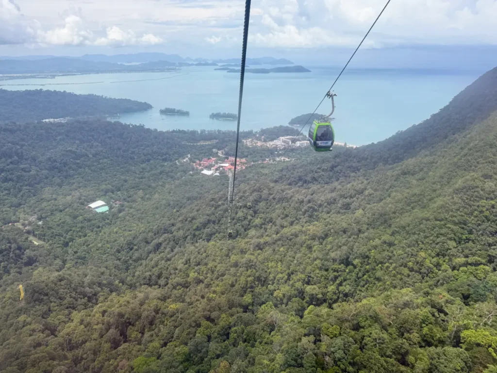 Langkawi SkyCab cable car gliding over forested mountains with ocean views