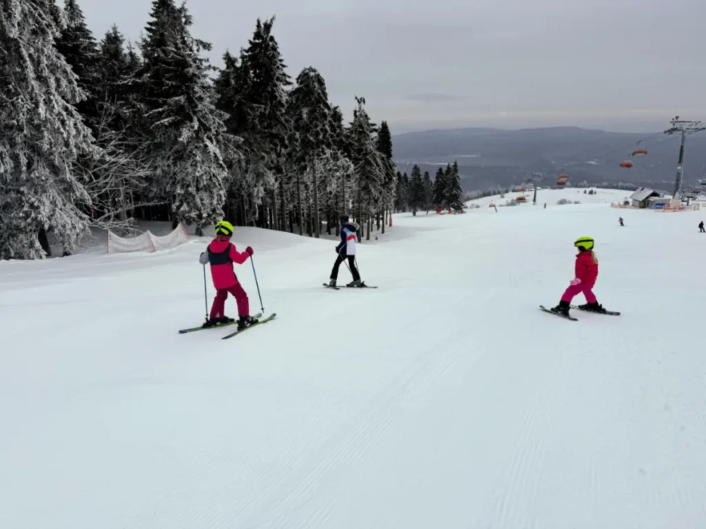 Family skiing on gentle slopes at Zieleniec Ski Arena, a beginner ski resort in Poland perfect for families with kids